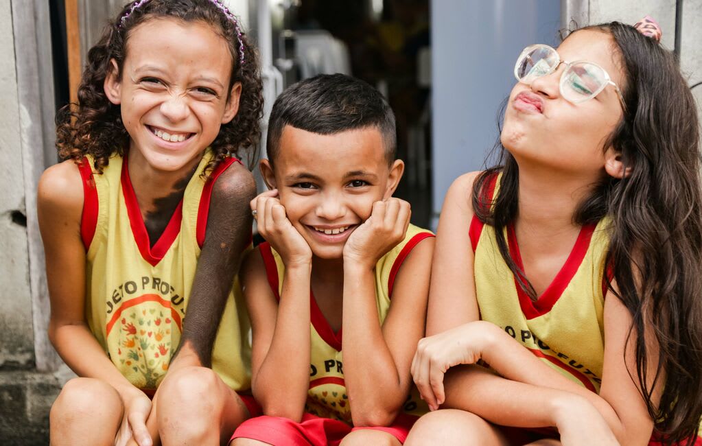 Three friends wearing a uniform make funny faces at the camera.